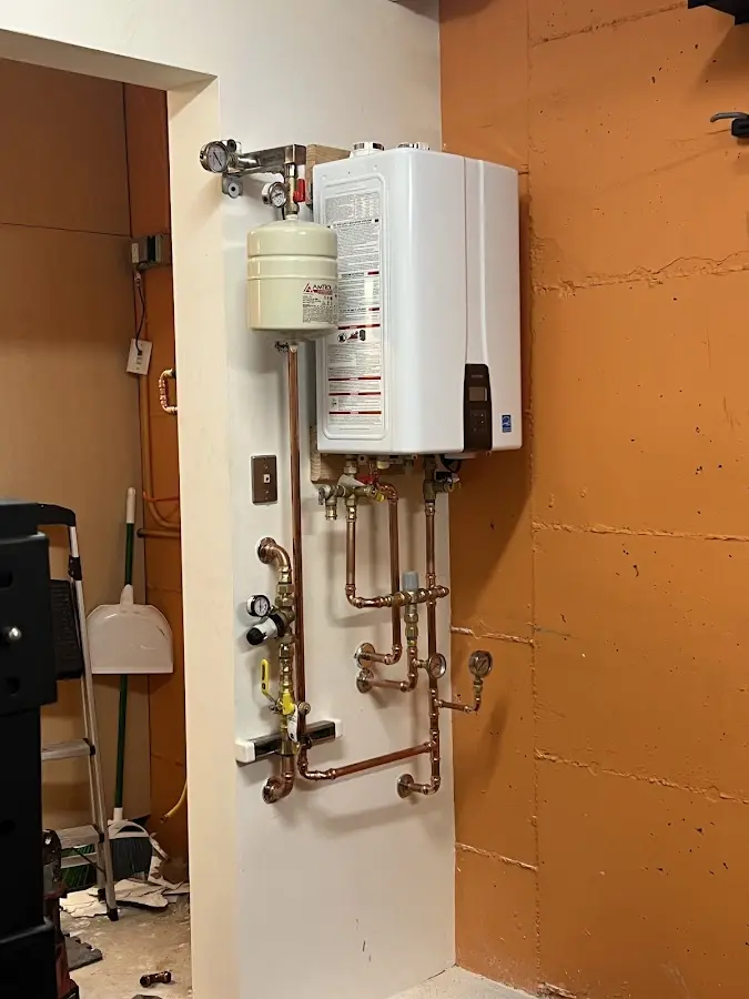 Plumbing technician inspecting water heater connections in Norco